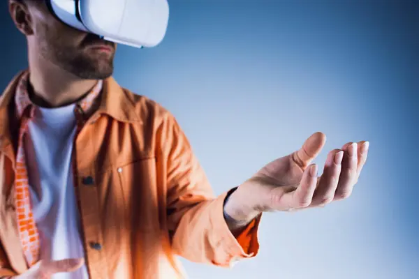 A man in a studio setting wearing a virtual reality glasses, exploring the Metaverse. — Stock Photo