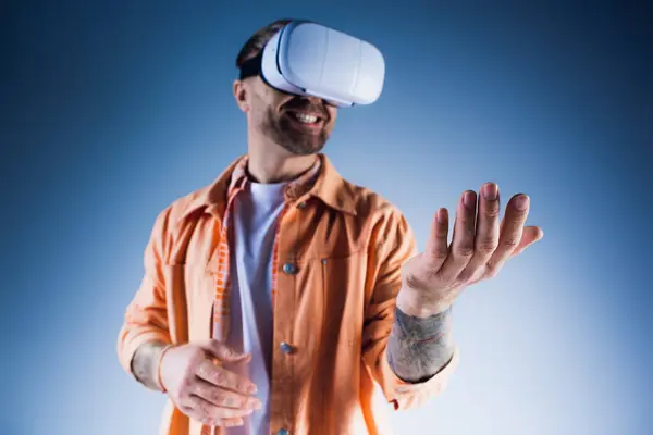 Ein Mann, der ein virtuelles Headset trägt, während er im Studio in die Metaverse eintaucht. — Stockfoto