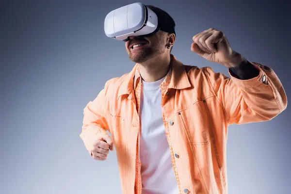 A stylish man in an orange shirt and white vr poses in a vibrant blue setting. — Stock Photo