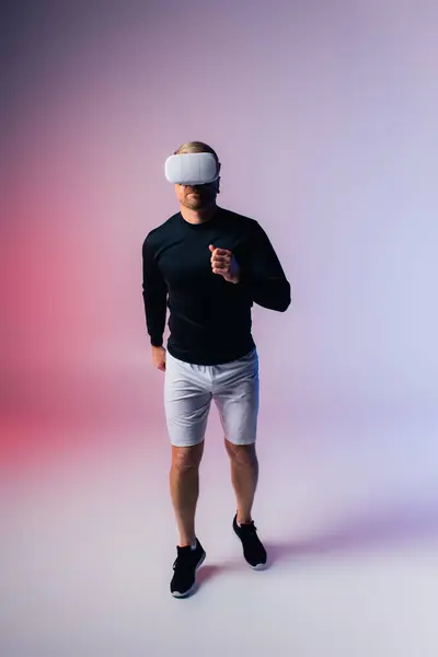 A man in a black shirt and white shorts stands confidently in a studio setting, exuding style and elegance with his outfit choice. — Stock Photo