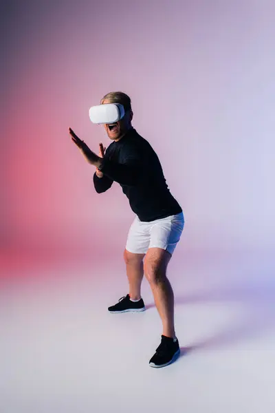 A man in a black shirt and white shorts poses confidently in a studio setting, creating a striking contrast in vr — Stock Photo