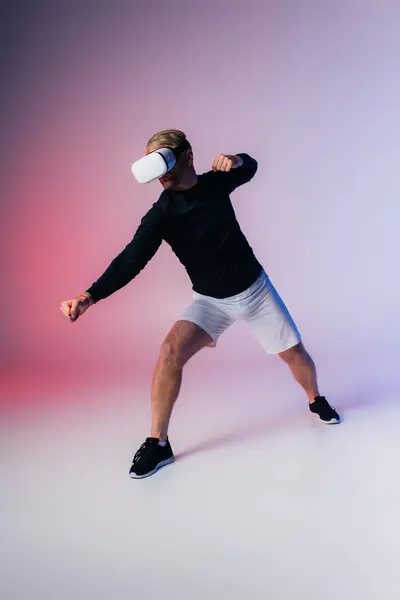 A man clad in a black shirt and white shorts explores the immersive Metaverse within a studio setting. — Stock Photo