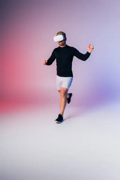 Ein Mann in schwarzem Hemd und weißer Hose sprintet zielstrebig in sein vr-Headset — Stockfoto