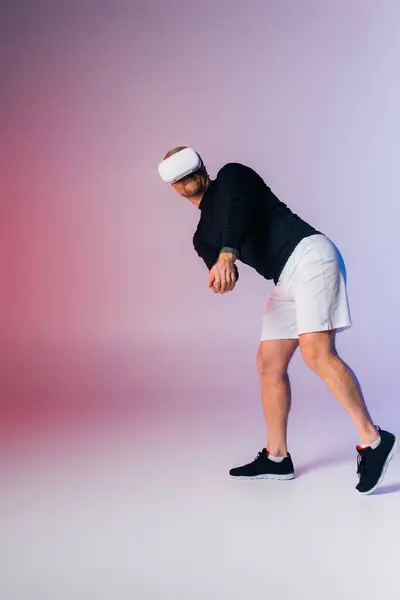 Um homem de camisa preta e calções brancos está energeticamente jogando tênis em uma quadra. — Fotografia de Stock