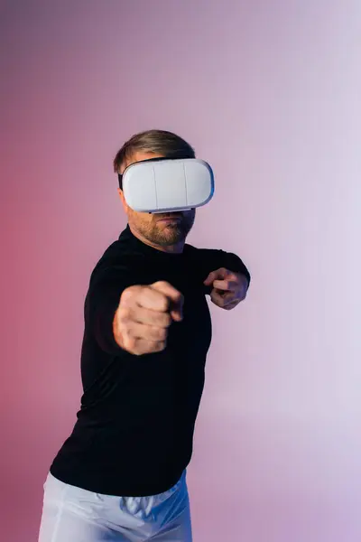A man in a black shirt and white shorts, wearing a blindfold, stands immersed in the metaverse experience in a virtual reality studio. — Stock Photo