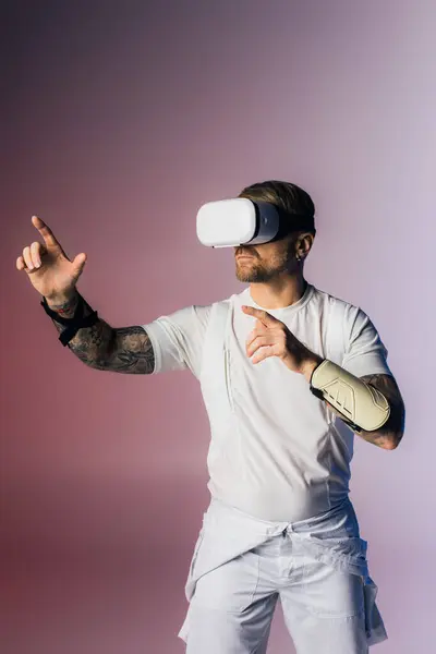 Чоловік у гарнітурі VR, одягнений у білу сорочку та білі шорти, досліджує метаверсію в студійній обстановці. — стокове фото