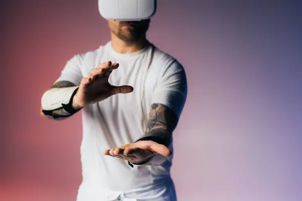 Um homem com uma camisa branca estende as mãos em um gesto de abertura e conexão, banhado em iluminação suave estúdio. — Fotografia de Stock