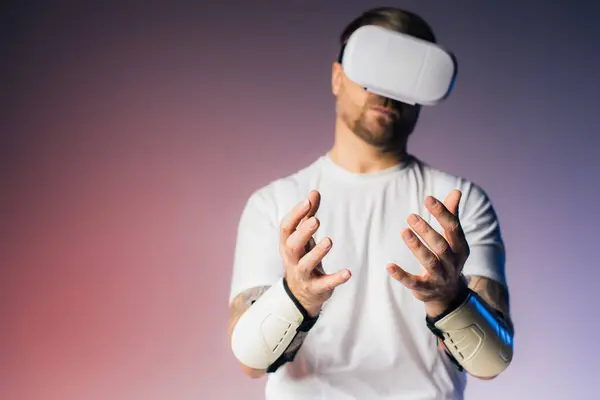 A man in a white shirt donning wrist braces in a virtual reality studio setting. — Stock Photo
