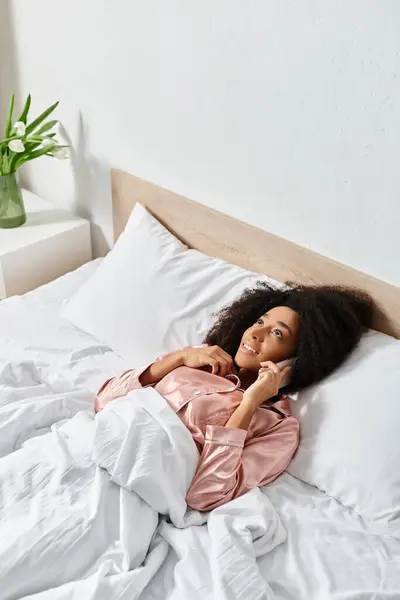 A doll rests peacefully on a neatly made bed with white sheets, adding a touch of whimsy to the cozy bedroom setting. — Stock Photo
