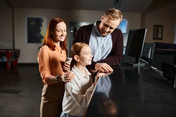 Un hombre, una mujer y un niño están juntos, sonriendo, disfrutando de una salida de película como una familia feliz. - foto de stock