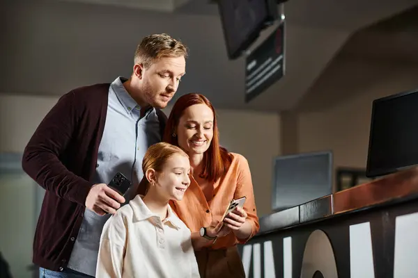 Family engrossed in a cell phone, sharing a moment of modern connectivity. — Stock Photo