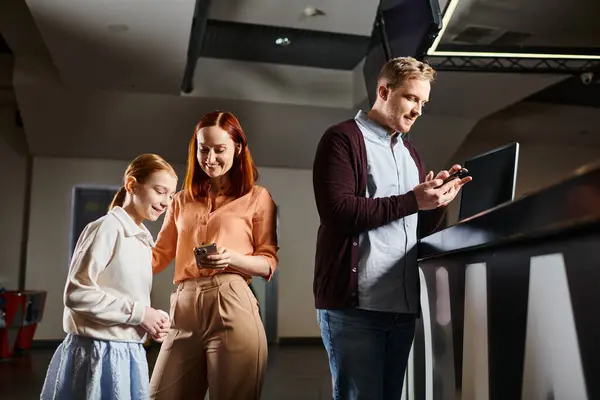 People joyfully engaged with a cell phone, bonding as a happy family in a cozy setting. — Stock Photo