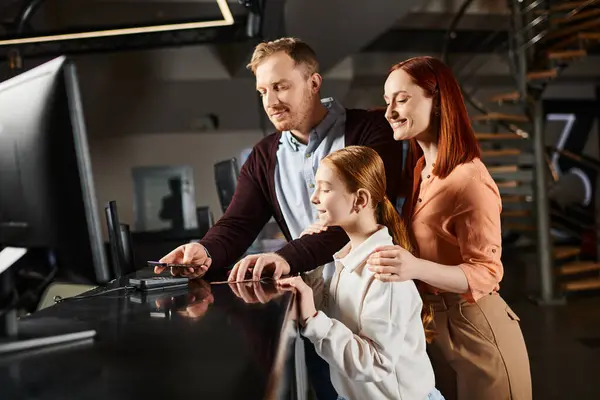 Мужчина и две женщины взаимодействуют с экраном компьютера, проявляя любопытство и сотрудничество в яркий момент совместного исследования. — стоковое фото