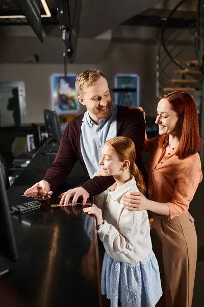 Family engage with a computer, sharing smiles and laughter in a bonding moment. — Stock Photo