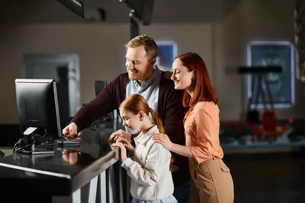 Familia reunida alrededor de una pantalla de ordenador, comprometida e interactuando con la tecnología. - foto de stock