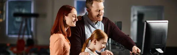 A man and family happily look at a computer screen together, engrossed in the digital world unfolding before them. — Stock Photo