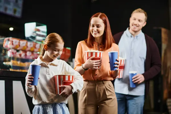 A happy family stands together, each holding a cup, enjoying a moment of togetherness. — Stock Photo