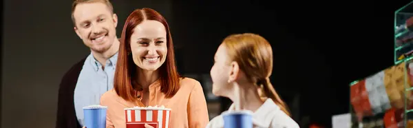 Family stand together, radiating happiness and togetherness as they enjoy a day out in the cinema. — Stock Photo