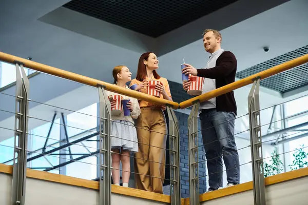 Un groupe de personnes debout sur un balcon surplombant la ville, se connectant entre eux dans le cinéma — Photo de stock