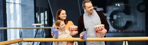 Ein Mann und seine Familie essen fröhlich Popcorn, während sie einen gemeinsamen Kinoabend genießen. — Stockfoto