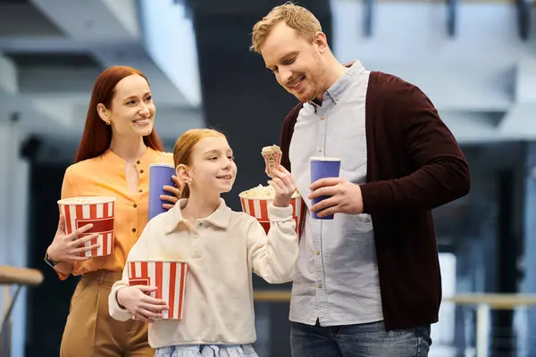 Una famiglia felice in piedi in un cerchio, legando e godendo di tempo di qualità insieme al cinema. — Foto stock