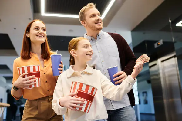 Семья счастливо держать чашки попкорна, связываясь вместе, как прогулка в кино. — стоковое фото