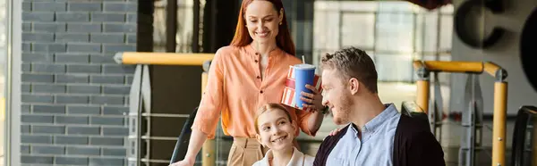 Famiglia cammina gioiosamente lungo una strada vivace, godendosi reciprocamente la compagnia in una giornata di sole. — Foto stock