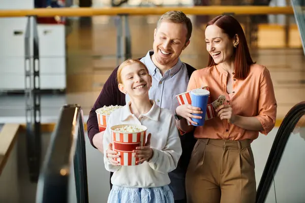 Una famiglia felice - uomo, donna e bambino - in piedi su una scala mobile, trascorrendo del tempo insieme. — Foto stock