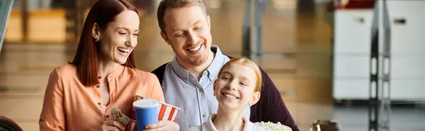 Famiglia stanno sorridendo insieme in un cinema, mostrando un forte legame e felicità. — Foto stock