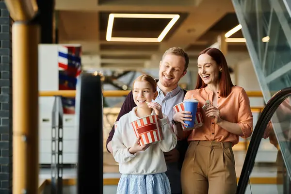 Un uomo, una donna e un bambino stanno su una scala mobile, ascendendo insieme in un momento di unità familiare. — Foto stock