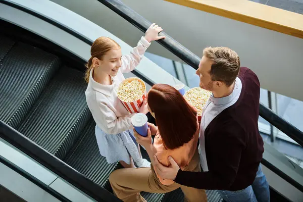 Un gruppo di persone, tra cui una famiglia felice, in piedi insieme su una scala mobile, salendo con grazia. — Foto stock