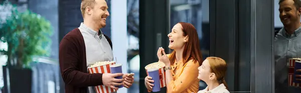 A happy family stands inside of a cinema building. — Stock Photo