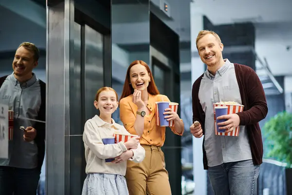 Una familia alegre se mantiene unida, unida en felicidad, en el cine. - foto de stock