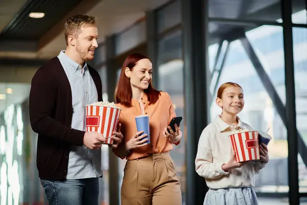 A happy family standing together in a cinema, enjoying a moment of togetherness before a movie. — Stock Photo