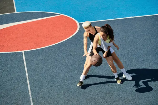 Deux femmes athlétiques se tiennent sur un terrain de basket-ball, célébrant leur amitié et leur amour pour le jeu lors d'une journée d'été ensoleillée. — Photo de stock