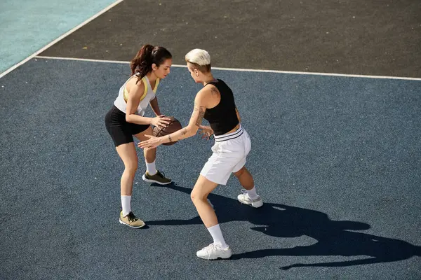 Дві спортсменки стоять тріумфально на тенісному корті, готові взяти на себе будь-якого суперника. — стокове фото