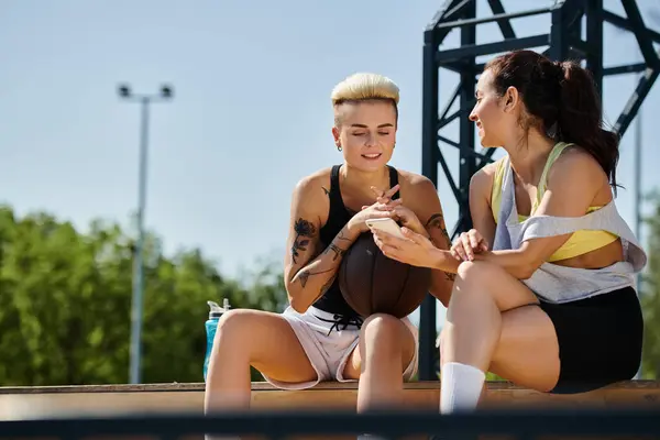 Two young women, friends and athletes, focus intently on playing basketball together outdoors on a sunny summer day. — Stock Photo