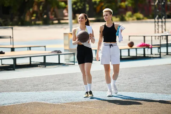 Дві спортсменки-друзі підкорюють баскетбольний майданчик у сонячний літній день. — стокове фото