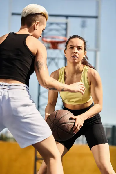 Друзья энергично играют в баскетбол на открытой площадке, демонстрируют свой атлетизм и спортивное мастерство. — стоковое фото