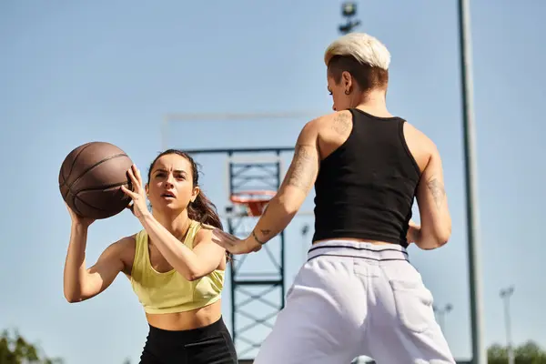 Amigos entusiasticamente jogar basquete ao ar livre em um dia ensolarado, mostrando suas habilidades atléticas e trabalho em equipe. — Fotografia de Stock
