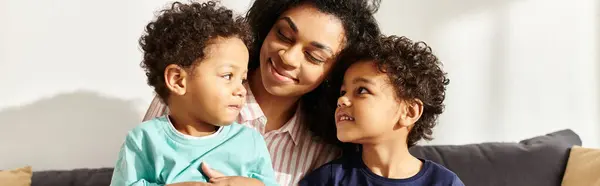 Joyeuse femme afro-américaine étreignant ses mignons petits fils qui tiennent présent, Fête des mères, bannière — Photo de stock