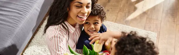 Cheerful african american woman receiving flowers from her adorable sons for Mothers day, banner — Stock Photo