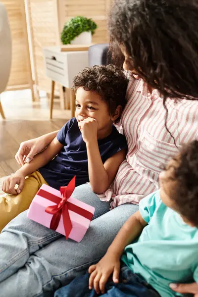 Cheerful appealing african american woman having great time with her sons, with present, Mothers day — Stock Photo