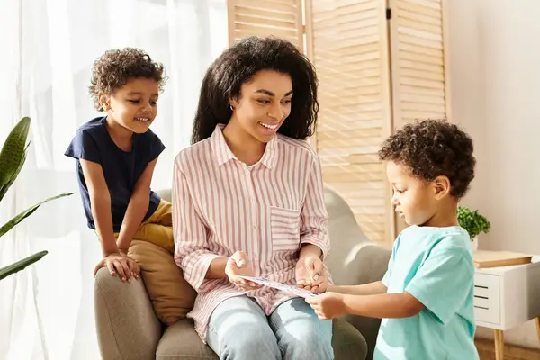 Jolly attractive african american woman receiving postcard from her little sons for Mothers day — Stock Photo