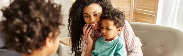 Surprised african american woman looking at her little blurred son and holding his brother, banner — Stock Photo