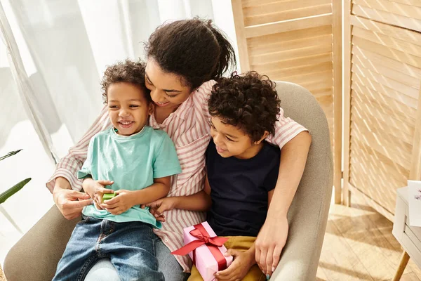 Joyeuse famille afro-américaine de trois passer du temps ensemble, présent dans les mains, fête des mères — Photo de stock