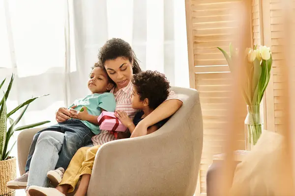Freudige afrikanisch-amerikanische dreiköpfige Familie, die gute Zeit miteinander hat, Gegenwart in der Hand, Muttertag — Stockfoto