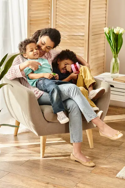 Fröhliche fürsorgliche afrikanisch-amerikanische Familie, die Zeit zusammen mit Geschenk in Händen verbringt, Muttertag — Stockfoto