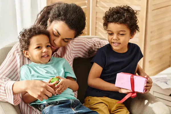 Familia afroamericana alegre en la ropa de casa pasar tiempo junto con el presente, Día de las madres - foto de stock