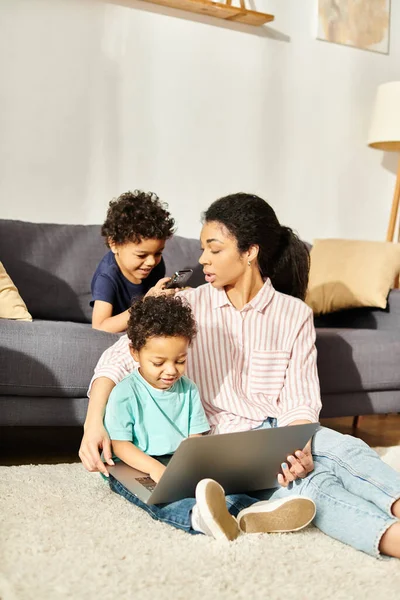 Belle femme afro-américaine en vêtements confortables passer du temps avec ses mignons petits fils — Photo de stock